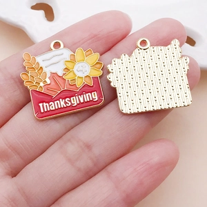 Detail of DIY Thanksgiving charms featuring sunflower, maple leaf and wheat on a gold base