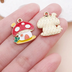 Macro detail showing colorful enamel mushroom pendants with golden plated textured back