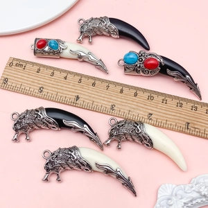 Pendentifs tribaux en résine avec têtes d'animaux argentées mesurés sur fond rose