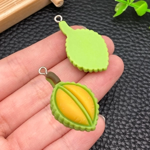 Dettaglio di pendente in resina a forma di durian con texture di buccia, polpa e anello