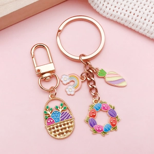 Easter egg and rabbit metal charms set with colorful enamel pendants on pink background