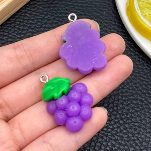 Dettaglio macro di ciondoli a uva in resina viola con foglie per gioielli fai-da-te