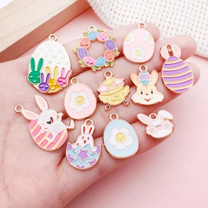 Macro detail of assorted enamel Easter rabbit and egg alloy charms held in a hand