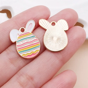 Detail view of colorful enamel Easter egg pendants with gold plating and sunburst texture