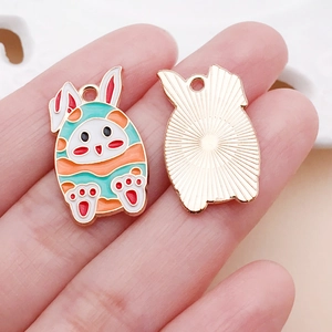Detailed view of colorful enamel Easter bunny pendants with wave pattern and gold metal backing