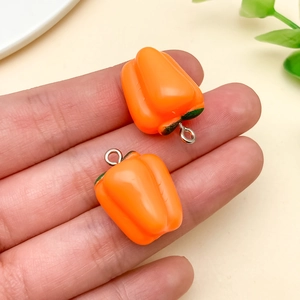 Detail von orangefarbenen Paprika-Anhängern aus Harz mit Ringen für DIY-Schlüsselanhänger