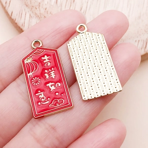 Détail de pendentif du Nouvel An en émail rouge avec caractères dorés chanceux