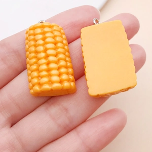 Detailed close-up of 3D resin corn charms for DIY crafts and keychain accessories