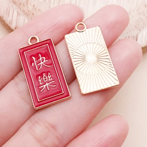 Gros plan d'un pendentif en émail rouge avec caractères chinois et motif soleil doré