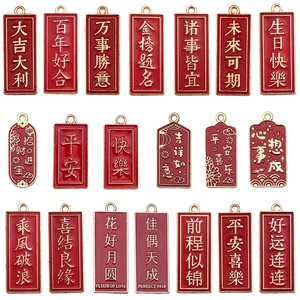 Pendentifs en émail rouge avec caractères dorés de vœux chinois sur fond blanc pur