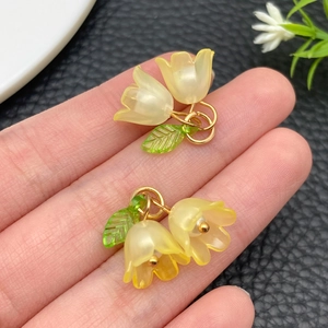 Detail van lelietje-van-dalen acryl hangers met groene bladeren voor DIY haaraccessoires
