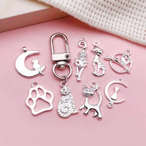 Silberne Katzen-Anhänger Set aus Legierung für DIY-Schmuck auf rosa Hintergrund