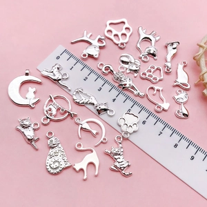 Silberne Katzen- und Pfotenanhänger aus Legierung für DIY-Schmuck auf rosa Grund