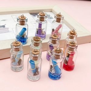 Mini bottiglie dei desideri in vetro con rotoli di carta colorati su sfondo rosa