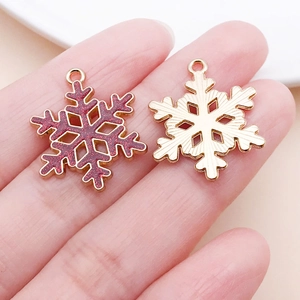 Nahaufnahme von roten Glitzer-Schneeflocken und Gold-Anhängern für DIY-Schmuck