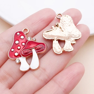 Detail of mushroom charms with red drip oil, rhinestones, and golden textured back