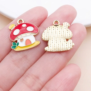 Macro shot of colorful enamel mushroom pendant held in hand for DIY jewelry making