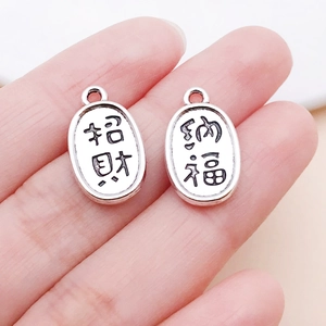 Detailed close-up of retro silver fortune charms featuring traditional Chinese engraving