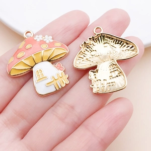 Macro detail of colorful enamel mushroom house charms with gold-plated metal backing