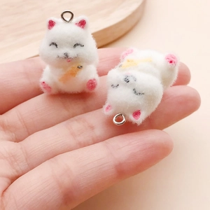 Detailed close-up of cute white flocked kitten pendants with soft fuzzy texture and rings