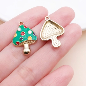 Detail of mushroom charms showing colorful enamel front and textured gold alloy back