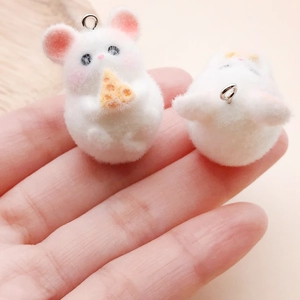 Close-up of white flocked hamster pendants with pink ears and cute cheese details