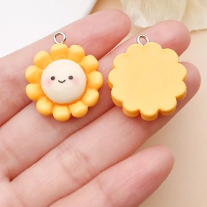 Vista dettagliata di ciondoli a girasole sorridenti in resina con anelli metallici