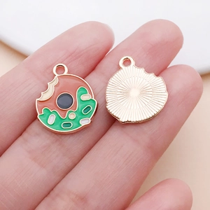 Macro-opname van dubbelzijdige emaille donut hanger met gouden radiale textuur en ring