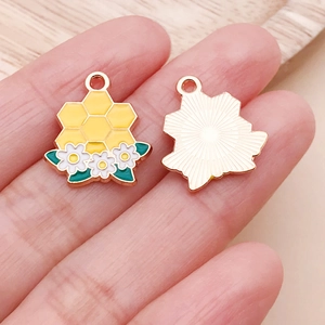 Macro shot of bee flower honeycomb pendant with enamel finish and gold metal sunburst back