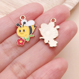 Macro shot of cute enamel bee charm for DIY jewelry making with gold-tone back texture