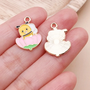 Close-up of cute bee and flower enamel charms showing front and back metal details