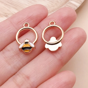 Macro detail of miniature yellow enamel bee charm showing front and back texture