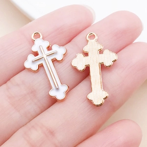 Vue détaillée des deux faces d'un pendentif croix en alliage argenté avec émail blanc