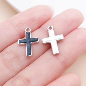 Gros plan détaillé de petits pendentifs en croix avec émail noir pour bijoux DIY