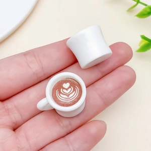 Mini-Kaffeetassen aus Harz mit Herz-Latte-Art, von Fingern gehalten zum Größenvergleich