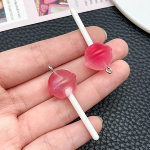 Macro shot of pink glitter resin lollipop charms with silver rings for DIY jewelry