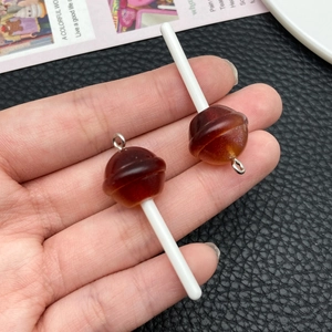 Detailed macro of two glittery brown resin lollipop charms with silver rings for DIY crafts