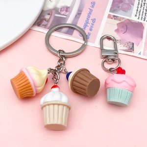 Schattige hars cupcake sleutelhangers met hartpatronen en metalen sluiting op roze achtergrond
