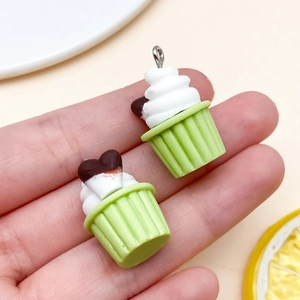 Detailopname van mini-cupcake hangers van hars met crème en hartvormig decor