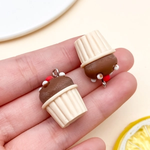 Macro-opname van hars chocolade cupcake bedeltjes met kralen en metalen ringen