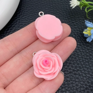Detailopname van een roze hars roos hanger met metalen lus voor doe-het-zelf sieraden