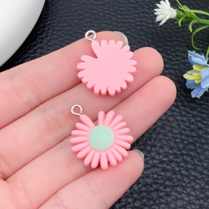 Detailopname van roze hars bloemenhangers in de hand voor DIY sieraden maken