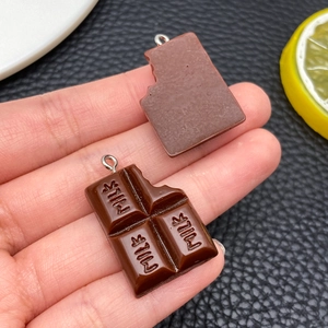 Detail van hars chocolade bedeltjes met Milk tekst en gebeten rand voor DIY-ambachten