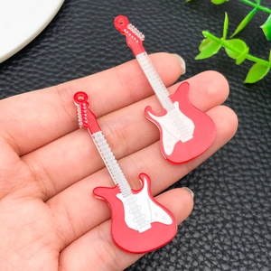 Macro detail of red acrylic electric guitar pendants for DIY keychain accessories