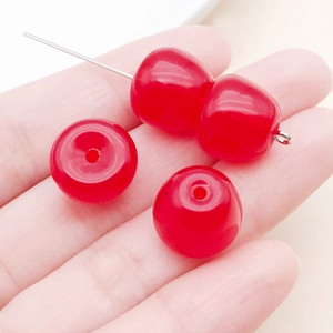 Gros plan de pendentifs cerise en acrylique rouge pour bijoux DIY à la main