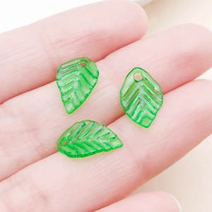 Gros plan de pendentifs feuilles en acrylique vert avec nervures et trous pour bijoux DIY