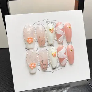 Handmade press-on nails set with long coffin shape, floral accents, and pearls