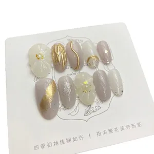 Handmade almond press-on nails in light purple and white with floral 3D relief details