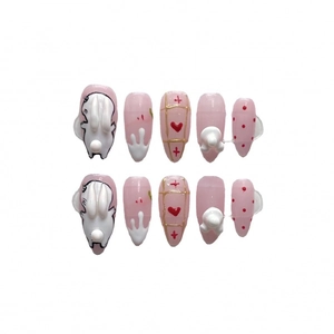 Pink Rococo press-on nails featuring 3D white bunnies and heart patterns, almond shape