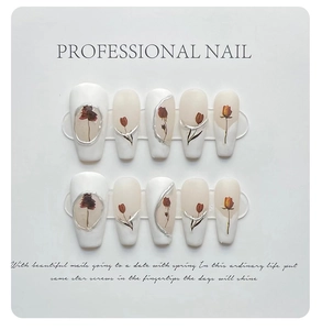 Detail of handmade press-on nails featuring dried flowers and silver 3D embossed edges